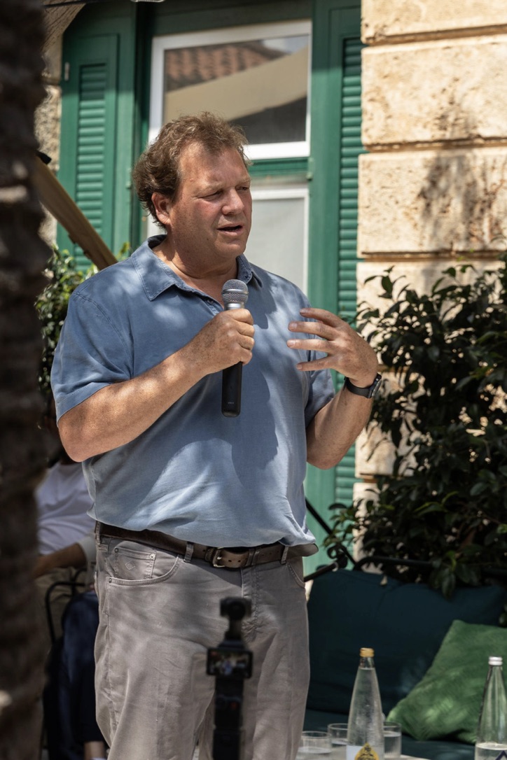 A faculty member speaking to the circle in the garden