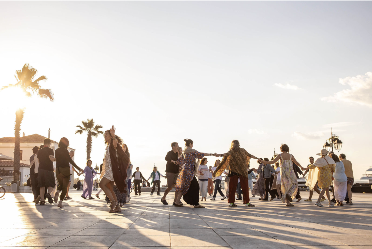 The circle dancing together at golden hour on the Spetses waterfront