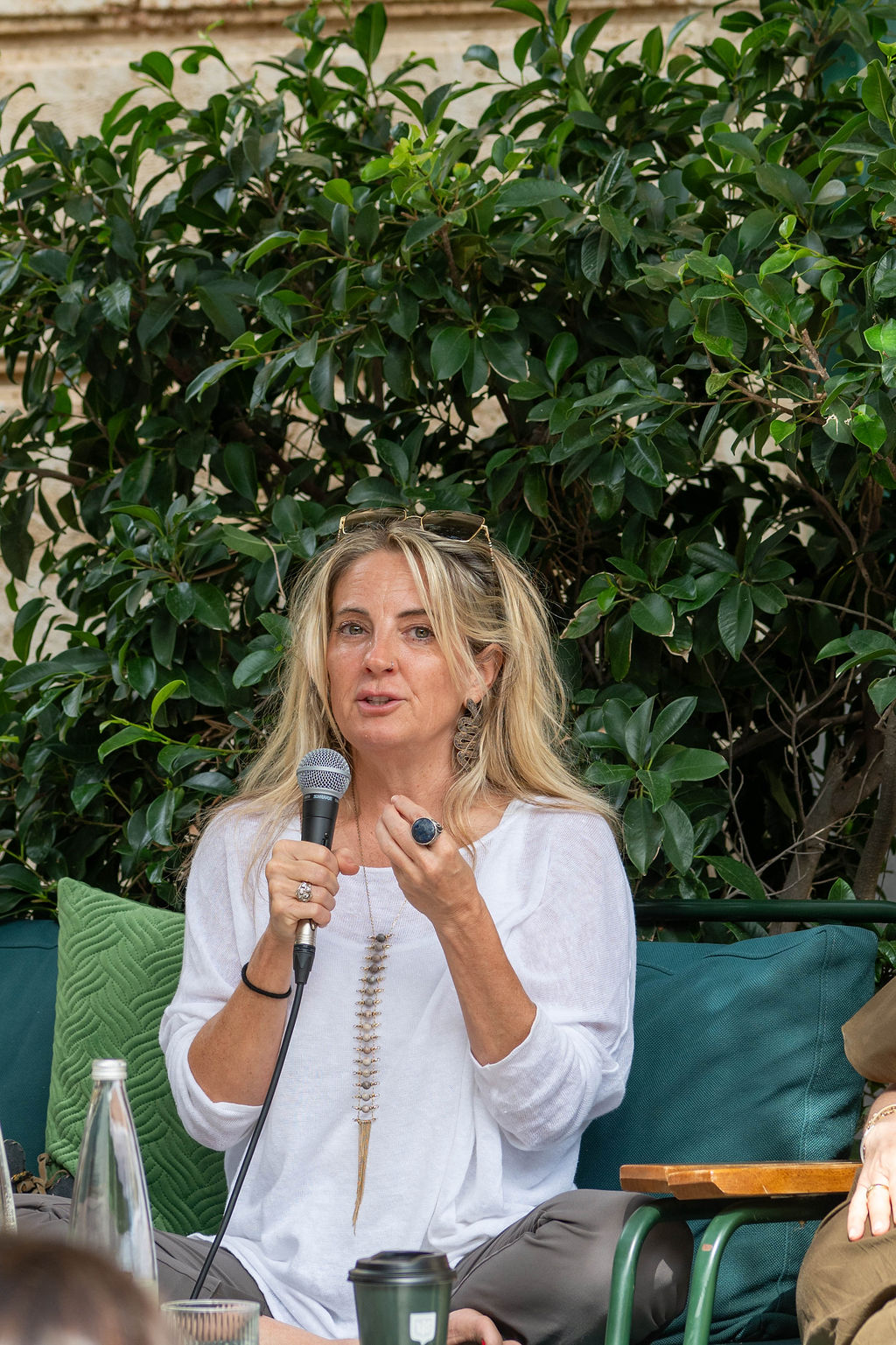 Lara Tambacopoulou speaking into the microphone at Spetses